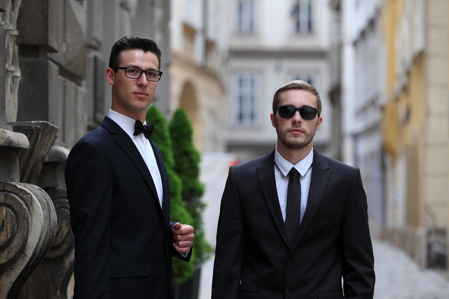Two handsome young men in black suits